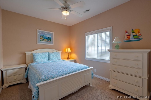 bedroom with visible vents, light colored carpet, baseboards, and ceiling fan