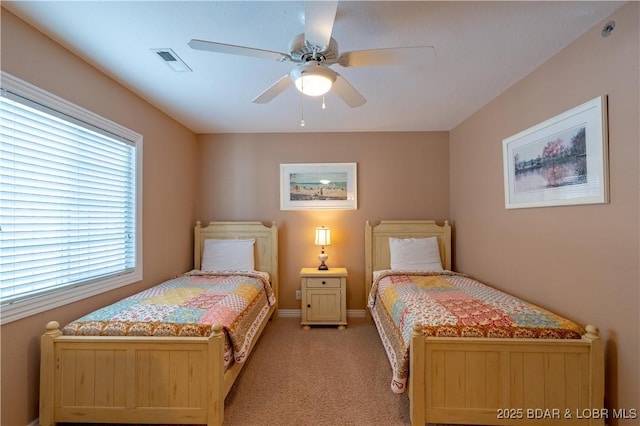 bedroom featuring visible vents, baseboards, light colored carpet, and ceiling fan