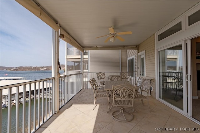 balcony featuring a ceiling fan and a water view