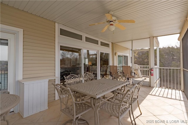 sunroom with outdoor dining space and a ceiling fan