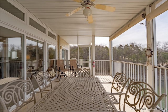 sunroom featuring outdoor dining area and ceiling fan