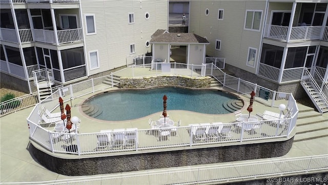 view of pool with a patio area, a sunroom, and fence