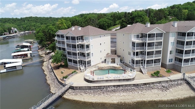drone / aerial view featuring a water view and a wooded view