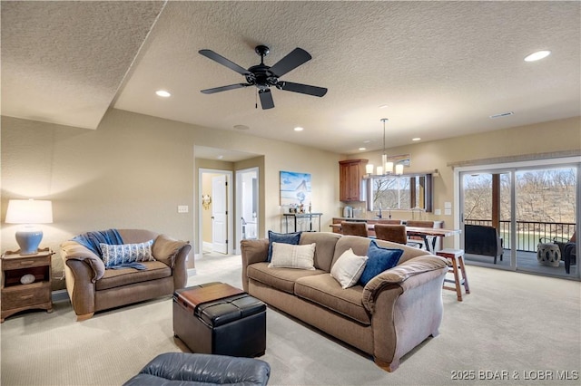 living area with light colored carpet, recessed lighting, a ceiling fan, a textured ceiling, and a chandelier