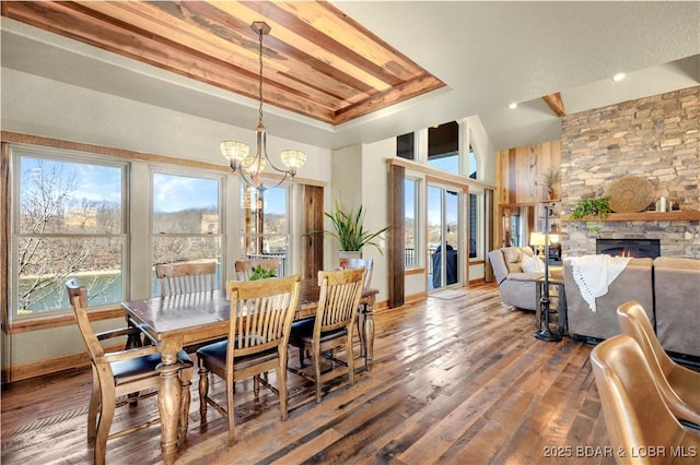 189 Black Rock Rd, Camdenton, MO 65020 - dining space with a raised ceiling, wood finished floors, a chandelier, a fireplace, and a towering ceiling