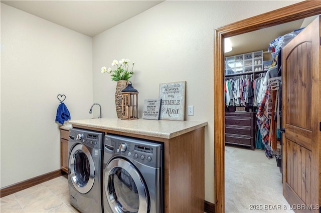 washroom with washer and clothes dryer and baseboards
