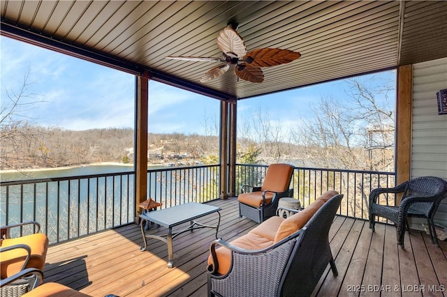 wooden deck with a water view and ceiling fan