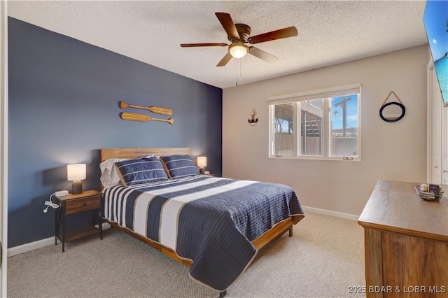 bedroom with carpet floors, a ceiling fan, baseboards, and a textured ceiling