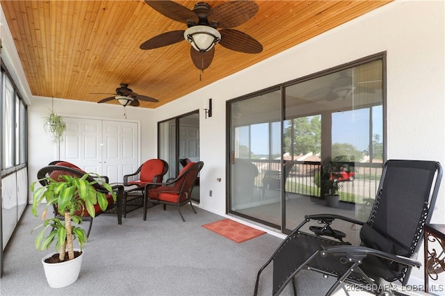 sunroom with wooden ceiling, ceiling fan, carpet, and baseboards