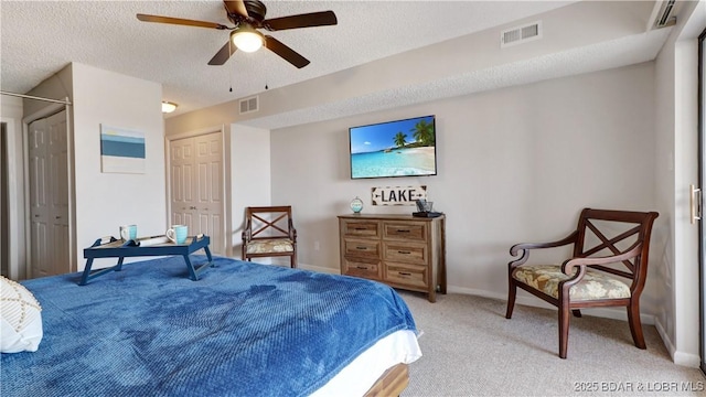 bedroom with visible vents, a textured ceiling, and light carpet