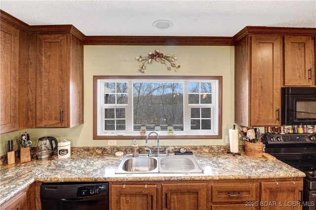 kitchen with brown cabinetry, a sink, and black appliances