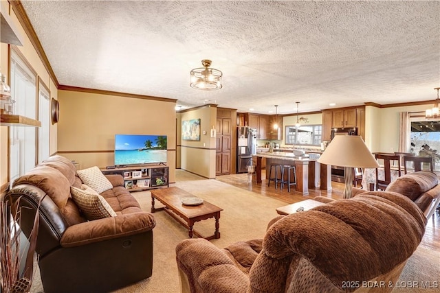 living room featuring an inviting chandelier, a textured ceiling, plenty of natural light, and crown molding