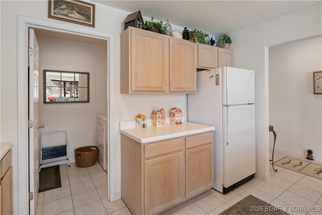 262 Bluff Blvd Unit 1B, Camdenton, MO 65020 - kitchen featuring light countertops, light tile patterned floors, light brown cabinetry, a textured ceiling, and freestanding refrigerator