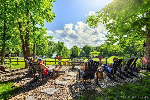 112 Waters Edge Ct Unit 2A, Lake Ozark, MO 65049 - view of yard featuring an outdoor fire pit, view of wooded area, and fence