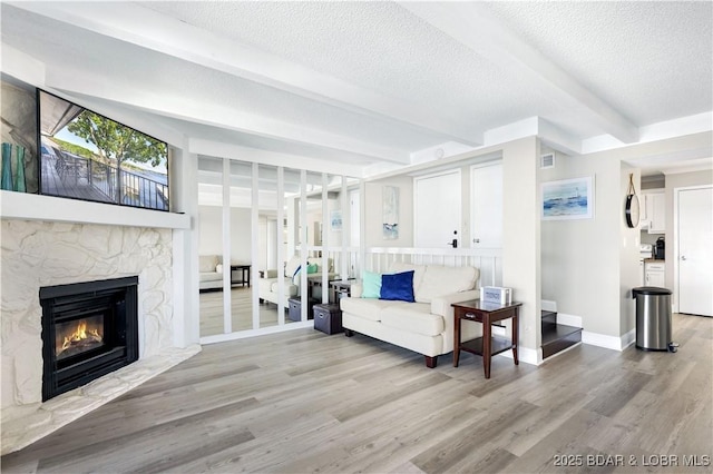 155 Circle Edge Dr Unit 3A, Lake Ozark, MO 65049 - living area with wood finished floors, beamed ceiling, a fireplace, baseboards, and visible vents