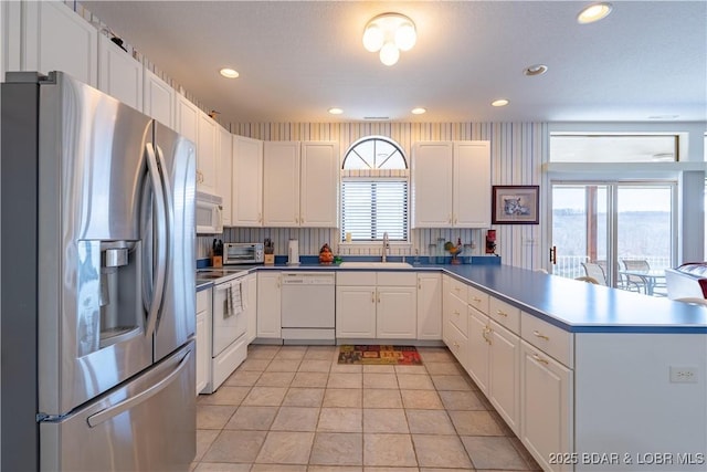 611 Lazy Days Rd Unit L6, Osage Beach, MO 65065 - kitchen featuring white appliances, a sink, a peninsula, white cabinetry, and recessed lighting