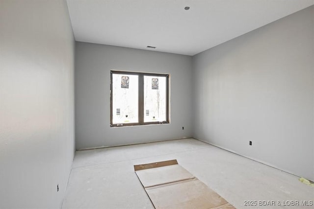 unfurnished room featuring visible vents