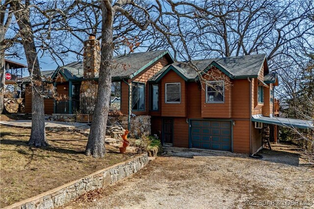 24 Arrowhead Beach Rd, Lake Ozark, MO 65049 - view of front facade featuring a garage, driveway, and a chimney
