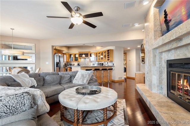 4465 Hamrock Ln Unit 502, Osage Beach, MO 65065 - living room featuring a ceiling fan, dark wood-style flooring, a fireplace, and visible vents