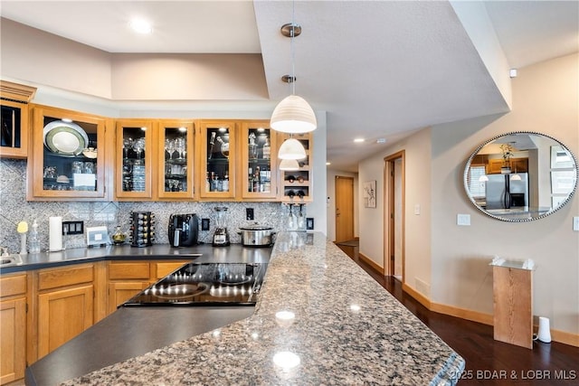 4465 Hamrock Ln Unit 502, Osage Beach, MO 65065 - kitchen featuring decorative backsplash, stainless steel fridge, dark wood-type flooring, glass insert cabinets, and decorative light fixtures
