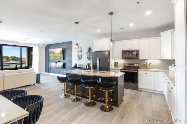 1045 Topsider Ln Unit 113, Osage Beach, MO 65065 - kitchen with appliances with stainless steel finishes, open floor plan, light wood-type flooring, backsplash, and recessed lighting