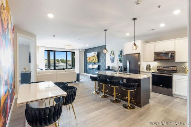 1045 Topsider Ln Unit 113, Osage Beach, MO 65065 - kitchen with stainless steel appliances, tasteful backsplash, open floor plan, light stone countertops, and recessed lighting
