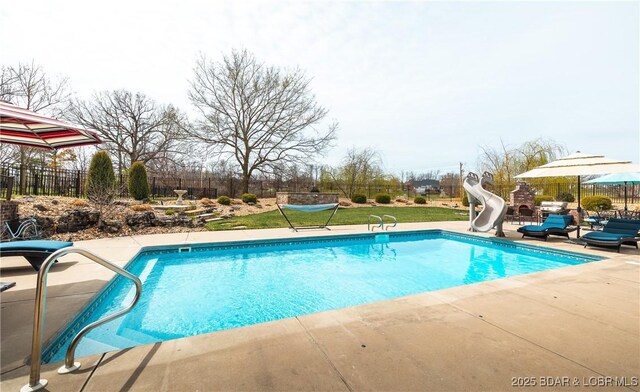 view of swimming pool with fence, a water slide, a patio area, and a fenced in pool