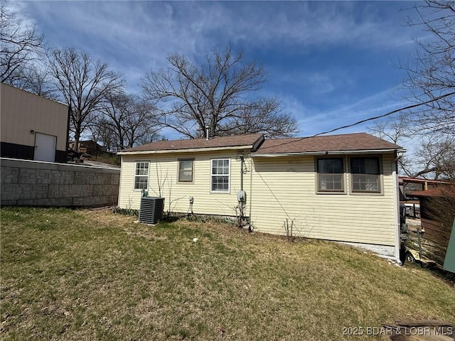 back of property featuring central AC unit, fence, and a yard