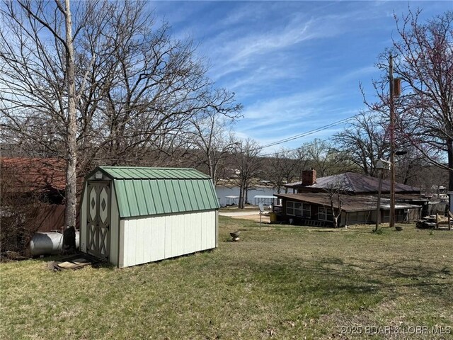 view of yard featuring heating fuel, a storage unit, an outdoor structure, and fence