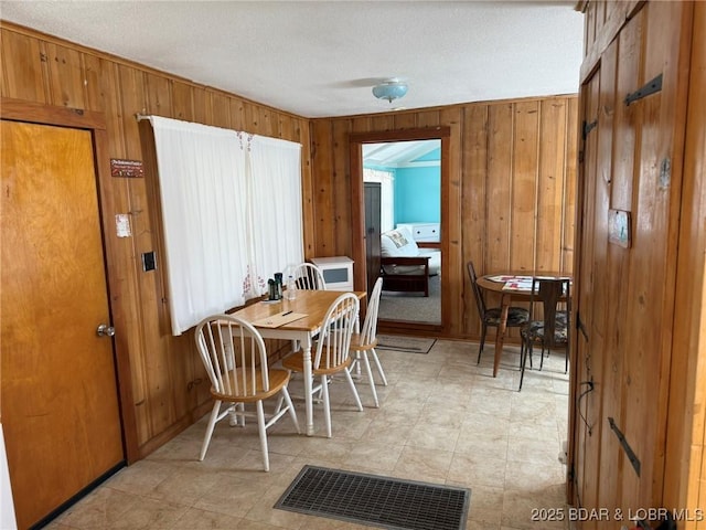 dining area featuring baseboards and wooden walls