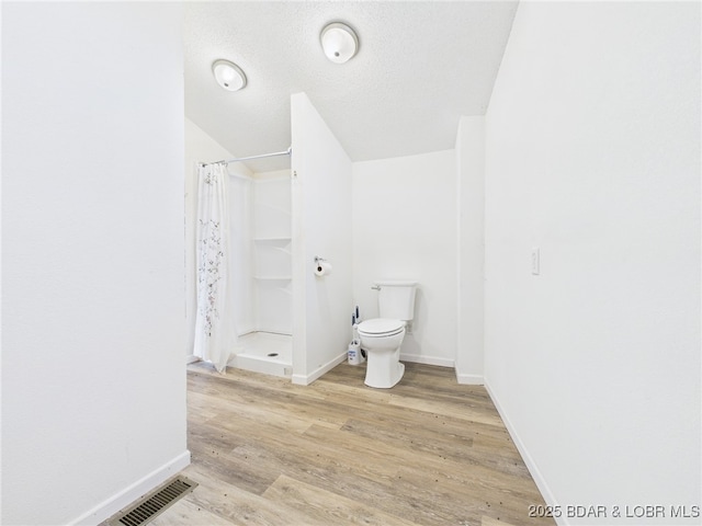 3760 Dogwood Dr, Stover, MO 65078 - bathroom with toilet, wood finished floors, a shower with curtain, visible vents, and baseboards