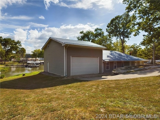 3760 Dogwood Dr, Stover, MO 65078 - view of side of home featuring metal roof, a water view, an attached garage, and a lawn
