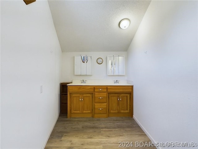 3760 Dogwood Dr, Stover, MO 65078 - bathroom featuring double vanity, wood finished floors, a sink, baseboards, and vaulted ceiling