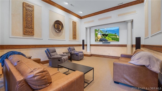 carpeted home theater room featuring ornate columns, a wainscoted wall, visible vents, and crown molding