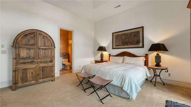 bedroom with light carpet, baseboards, visible vents, and connected bathroom