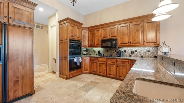 kitchen featuring dark stone countertops, backsplash, black appliances, and brown cabinetry