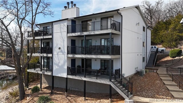 31347 Northshore Dr Unit 101A, Rocky Mount, MO 65072 - view of building exterior with stairway and central AC