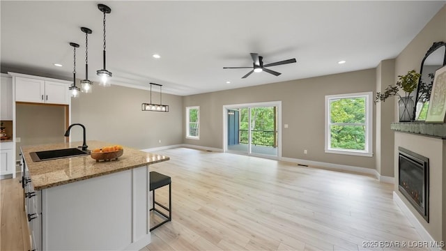 20311 Timberlake Village Ln, Rocky Mount, MO 65072 - kitchen featuring a sink, white cabinetry, open floor plan, light wood-style flooring, and ceiling fan