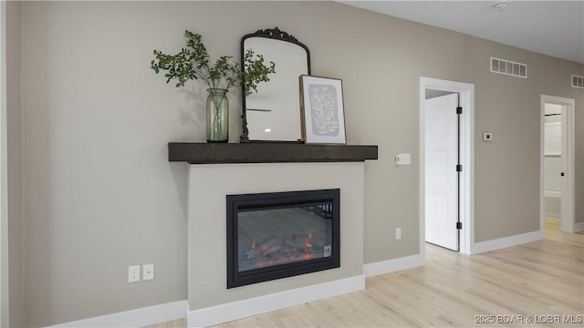 20311 Timberlake Village Ln, Rocky Mount, MO 65072 - interior details with baseboards, visible vents, wood finished floors, and a glass covered fireplace