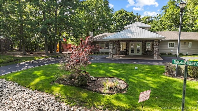 20311 Timberlake Village Ln, Rocky Mount, MO 65072 - rear view of house with french doors, stone siding, and a yard