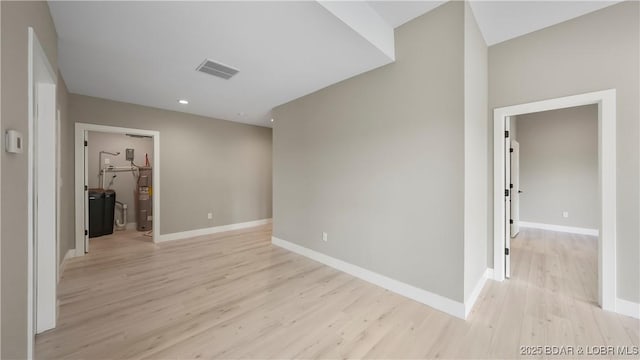 20311 Timberlake Village Ln, Rocky Mount, MO 65072 - spare room featuring light wood-style flooring, visible vents, baseboards, recessed lighting, and water heater