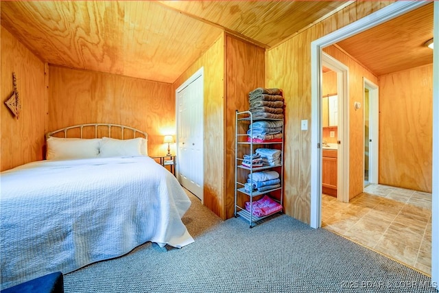 bedroom with carpet floors, wooden ceiling, and wooden walls