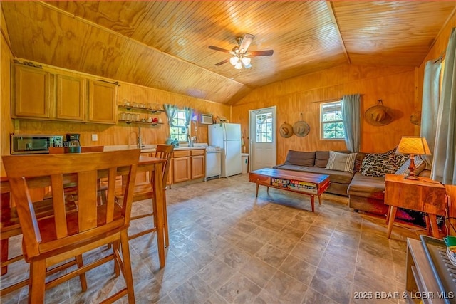 living room with wooden ceiling, wood walls, lofted ceiling, and ceiling fan