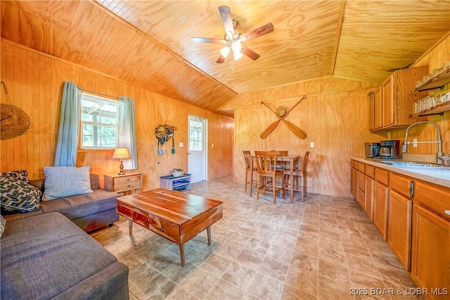 living room with wood ceiling, wooden walls, vaulted ceiling, and ceiling fan