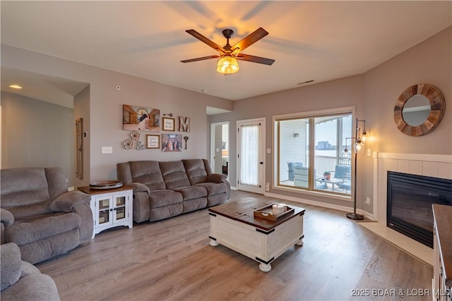 398 Regatta Bay Dr Unit 1A, Lake Ozark, MO 65049 - living room with light wood-type flooring, ceiling fan, and a tiled fireplace