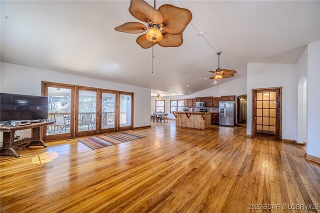 27394 Cross Ln, Barnett, MO 65011 - living area featuring ceiling fan, french doors, light wood finished floors, arched walkways, and high vaulted ceiling