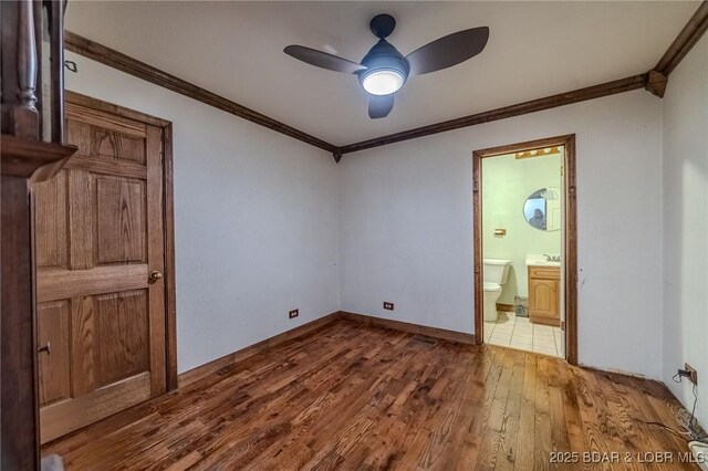 27394 Cross Ln, Barnett, MO 65011 - unfurnished bedroom with wood-type flooring, ornamental molding, connected bathroom, and ceiling fan