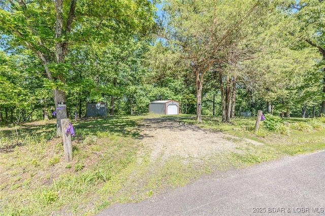 27394 Cross Ln, Barnett, MO 65011 - view of yard featuring a detached garage, an outdoor structure, and driveway