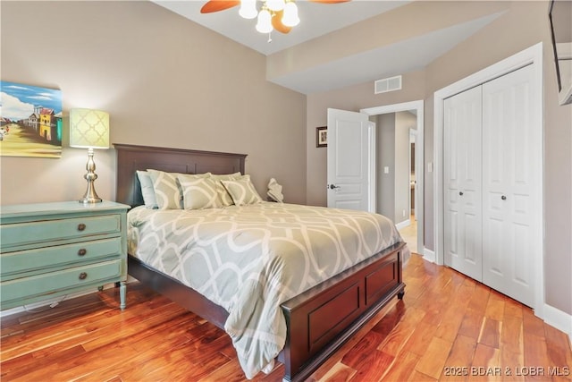 bedroom featuring wood finished floors, a closet, ceiling fan, and baseboards