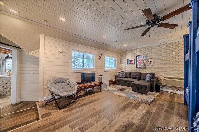 33271 Elaine Rd, Sunrise Beach, MO 65079 - living room with wood finished floors, ceiling fan, wooden ceiling, a wall unit AC, and brick wall